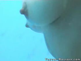 Молодая женщина переодевает купальник в пляжной кабинке