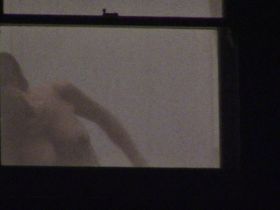 Девушка с большими сиськами стояла у окна и одевалась попадась на камеру