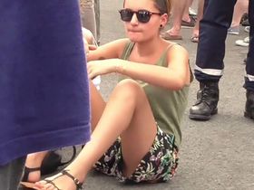 Очень симпатичная девушка села на землю в шортиках и случайно засветила пизденку в трусиках