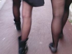 Две студентки прогуливаются по улице, а сзади их одногруппник снимает ан камеру ножки